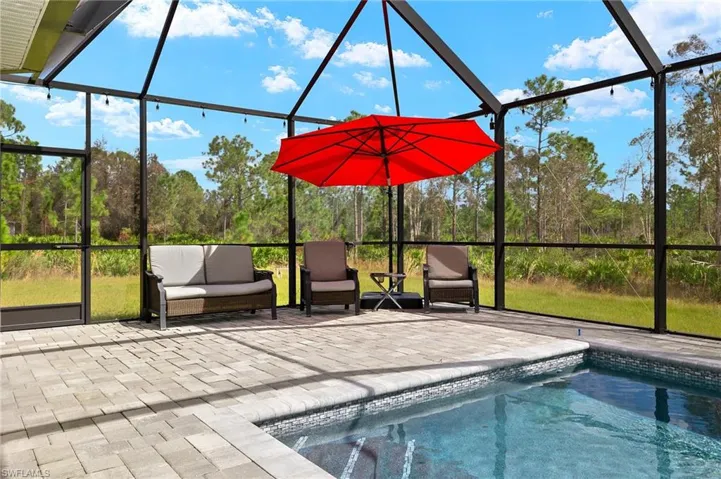 View of swimming pool featuring a lanai and a patio area