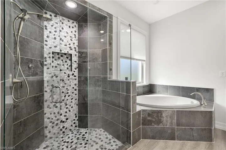 Bathroom with separate shower and tub and hardwood / wood-style flooring
