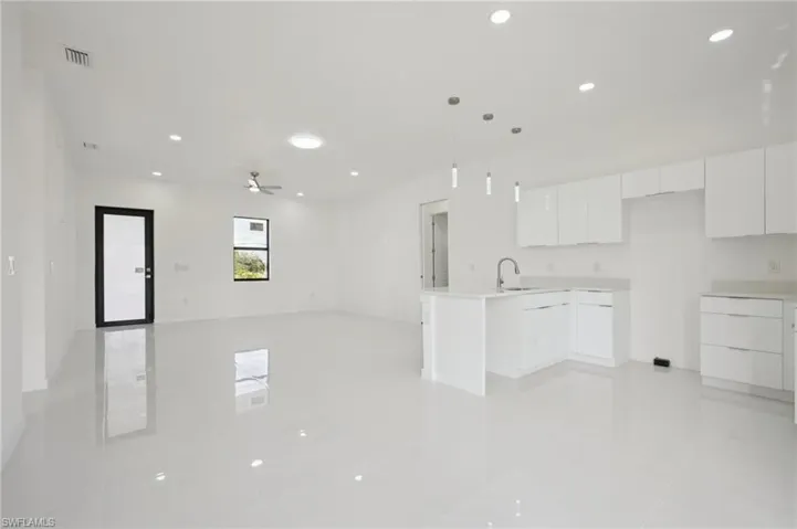 Kitchen featuring white cabinetry, open floor plan, a peninsula, recessed lighting, and modern cabinets