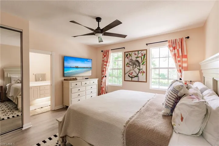 Bedroom with connected bathroom, light hardwood / wood-style flooring, and ceiling fan