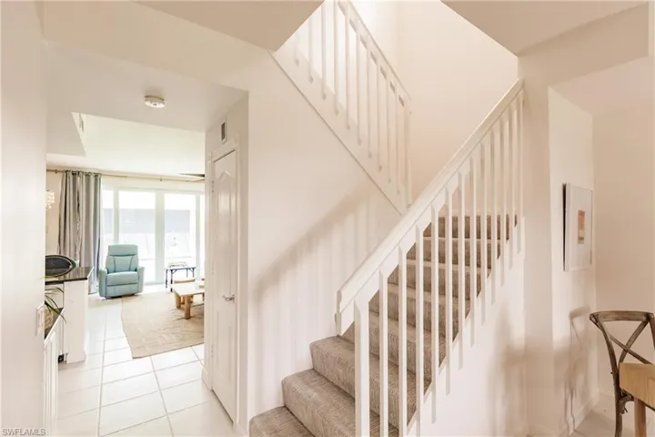 Staircase with light tile patterned floors