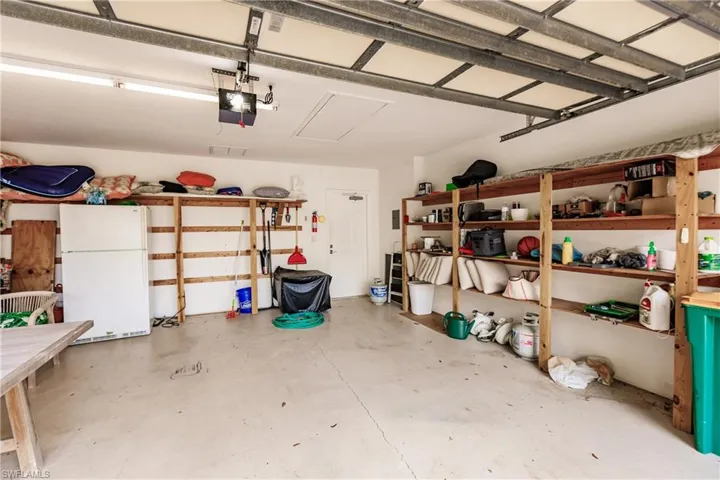 Garage with white refrigerator and a garage door opener