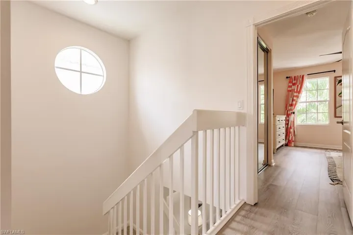 Hallway with hardwood / wood-style floors