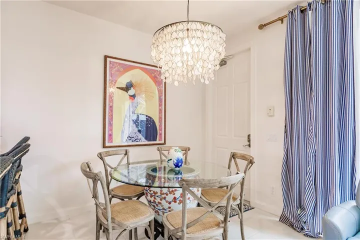 Dining room with light tile patterned floors and a chandelier