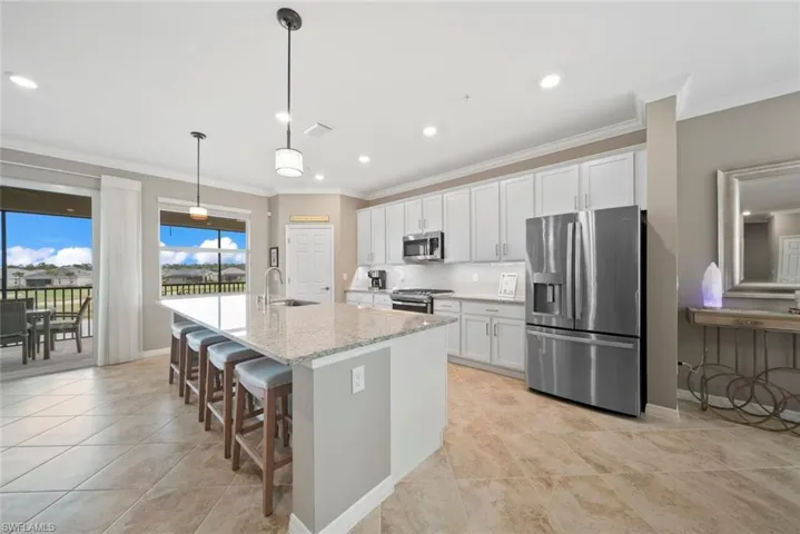 Kitchen featuring stainless steel appliances, sink, pendant lighting, and white cabinets