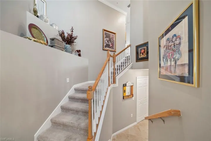 Stairs featuring ornamental molding and a high ceiling