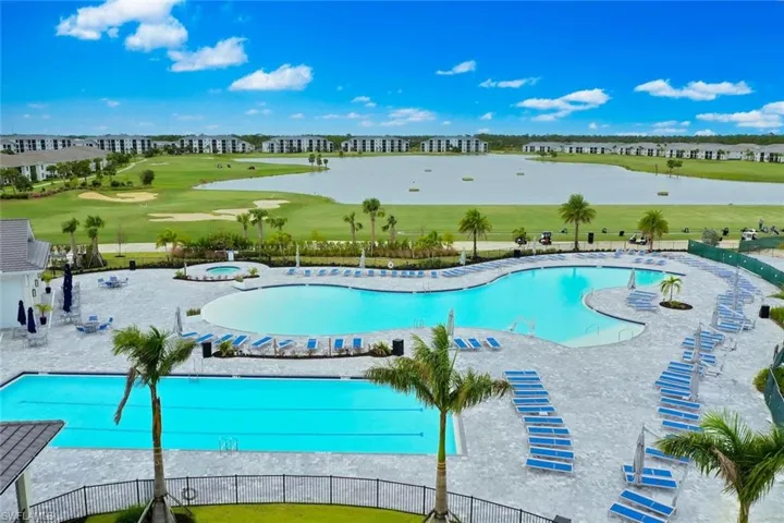 View of pool with a patio area, a water view, and a lawn