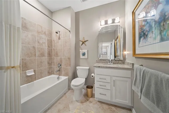 Full bathroom with vanity, shower / bath combo, and toilet