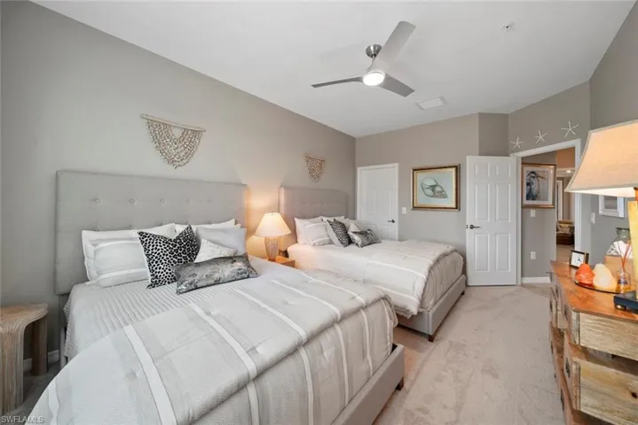 Bedroom with ceiling fan and light carpet