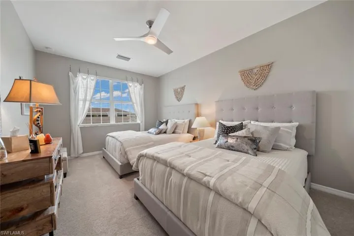 Carpeted bedroom featuring ceiling fan