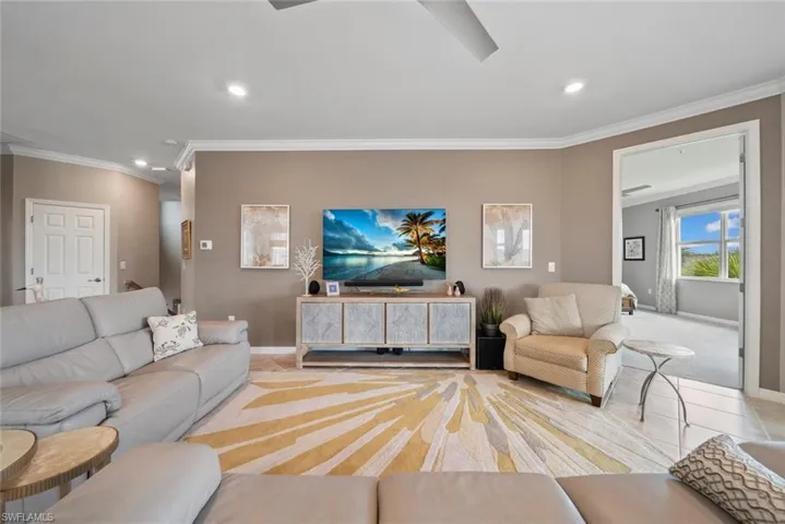 Living room with light carpet and ornamental molding