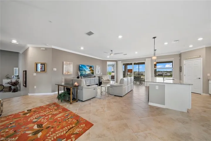 Living room with ornamental molding, sink, light tile patterned floors, and ceiling fan