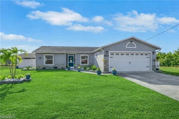 Ranch-style home with stone siding, stucco siding, concrete driveway, and a front lawn