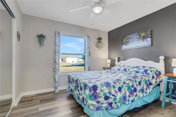 Bedroom featuring light wood finished floors, ceiling fan, and an accent wall