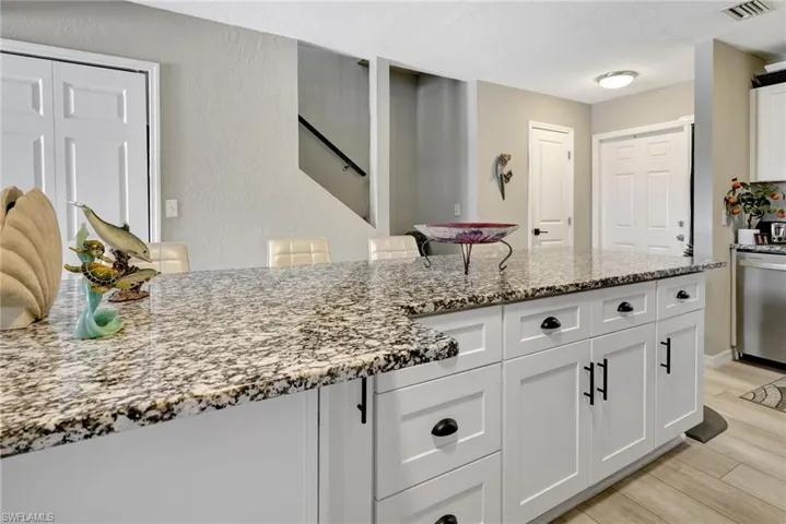 Kitchen featuring dishwasher, light hardwood / wood-style flooring, and white cabinets