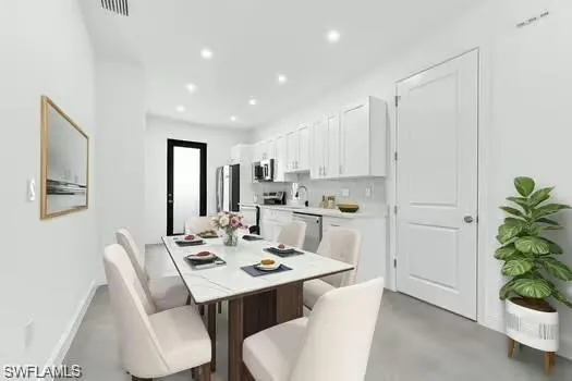 Dining room (Virtual Staged) with recessed lighting and concrete flooring