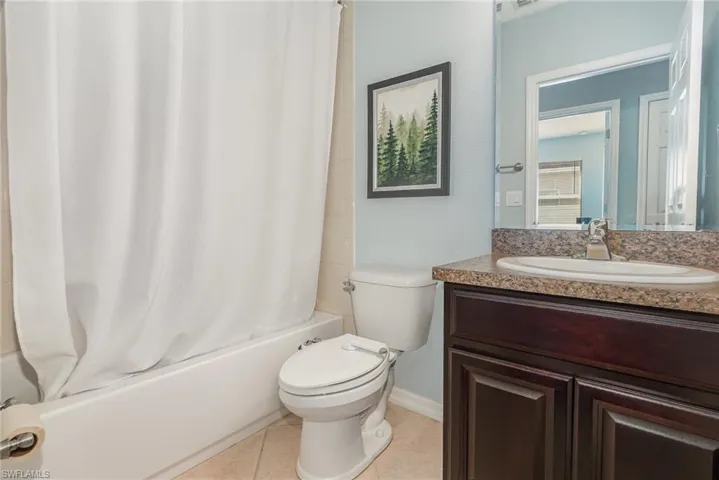 Full bath featuring tile patterned floors, vanity, toilet, and shower / tub combo