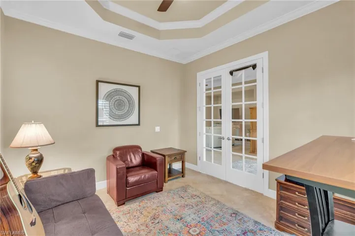 Living area featuring ceiling fan, french doors, light tile patterned floors, and ornamental molding