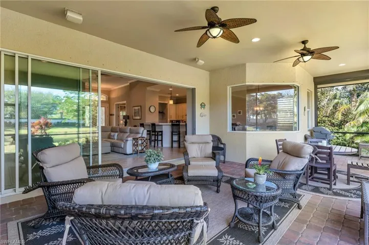 View of patio with outdoor lounge area, ceiling fan, and a bar