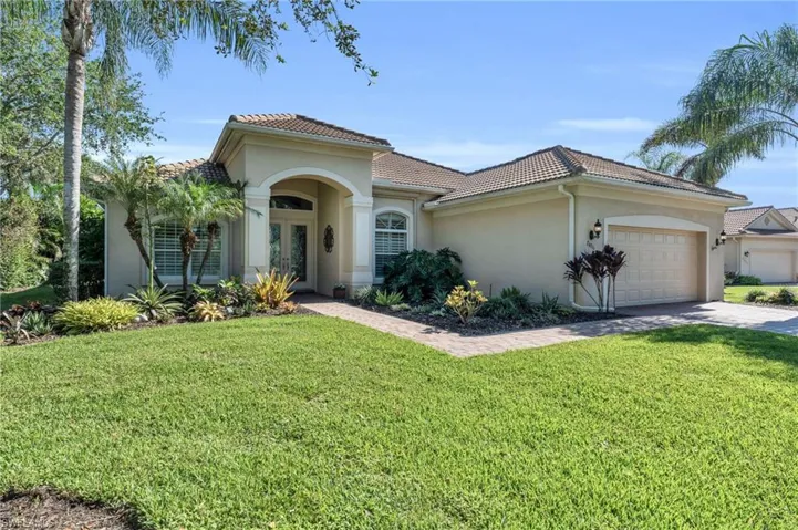 Mediterranean / spanish house featuring a front lawn, a garage, and french doors