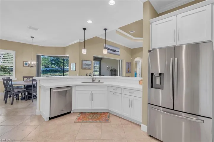 Kitchen featuring white cabinets, stainless steel appliances, crown molding, and sink