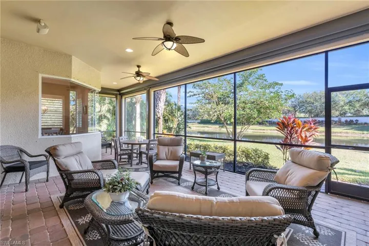 Sunroom / solarium featuring a wealth of natural light, ceiling fan, and a water view