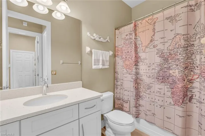 Full bathroom featuring vanity, toilet, and shower / bathtub combination with curtain