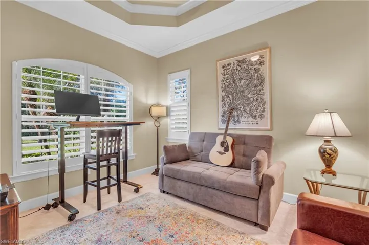 Tiled den area with pull out couch featuring plenty of natural light and ornamental molding