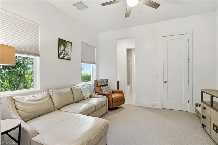 Carpeted living space featuring recessed lighting, a ceiling fan, and two windows with blinds