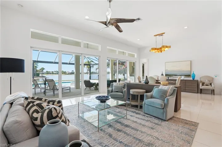 Open-concept living space featuring high ceilings, white tile flooring, and a contemporary ceiling fan