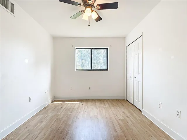 Unfurnished bedroom featuring light wood-style flooring, a closet, and ceiling fan
