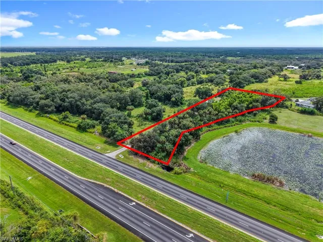Aerial view of property and surrounding area with a highway and property parcel outlined