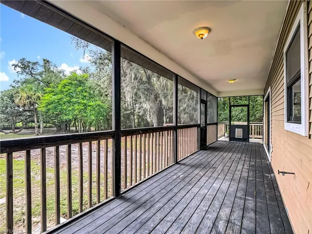 Unfurnished sunroom with a deck and view of wooded area