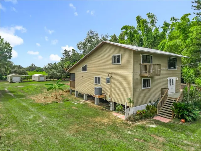 Back of property with a lawn and stairs