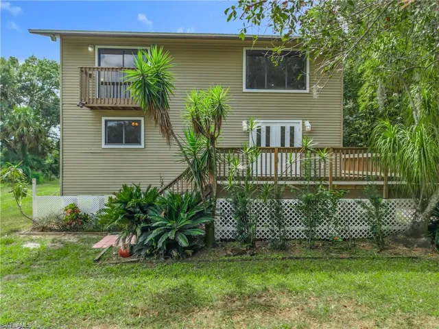 Back of house featuring a wooden deck and a yard
