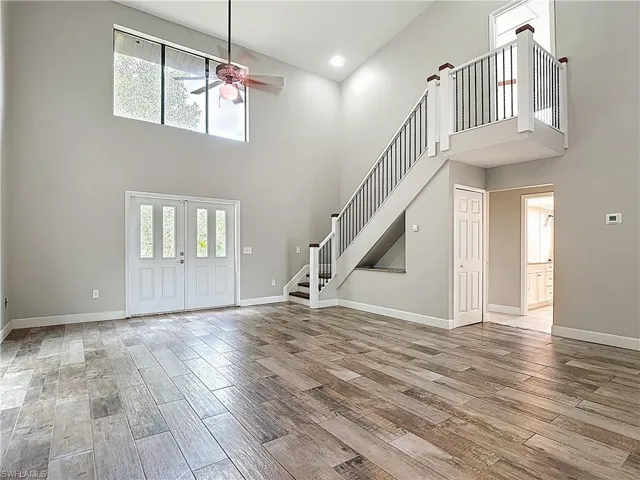 Entrance foyer with a towering ceiling, plenty of natural light, light wood-style flooring, ceiling fan, and recessed lighting