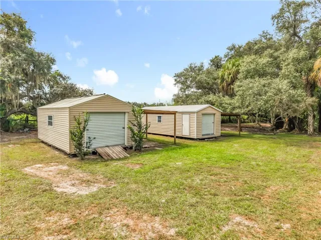 Rear view of house with a lawn and a storage shed