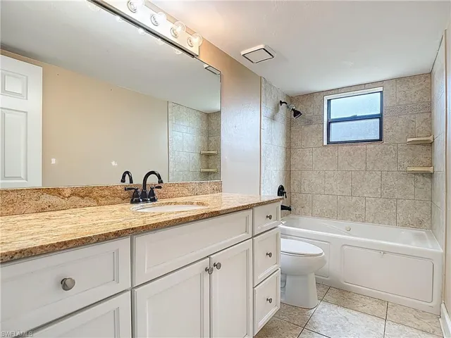Full bathroom featuring vanity, washtub / shower combination, and light tile patterned floors