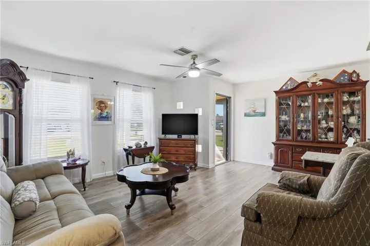 Living room with light wood finished floors and a ceiling fan