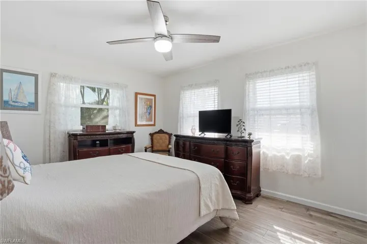 Bedroom with light wood-style floors and a ceiling fan