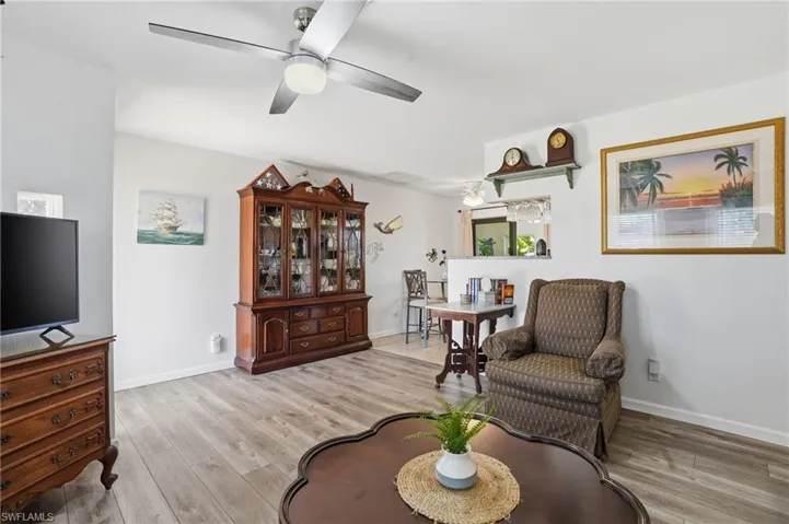 Sitting room with light wood-style flooring and a ceiling fan