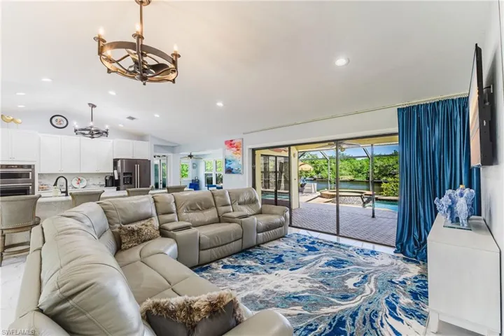 Spacious living area featuring white tile flooring and a sliding glass door