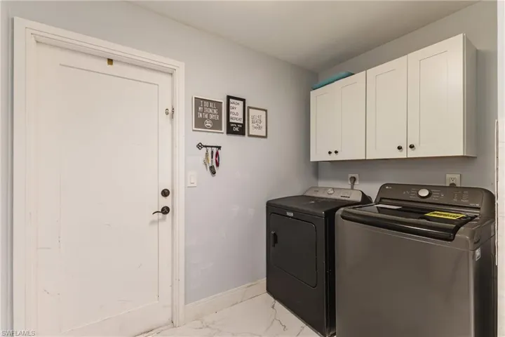 Laundry area featuring white shaker-style cabinetry with dark hardware and light-toned wall paint