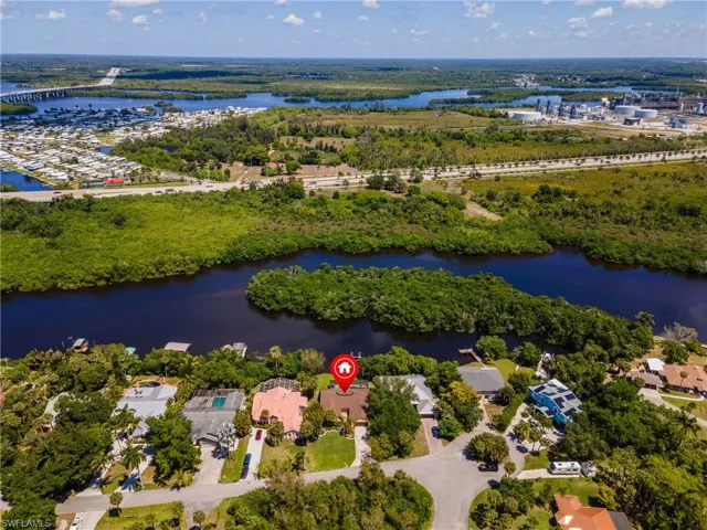Aerial perspective showcasing a residential property with surrounding waterways and lush vegetation