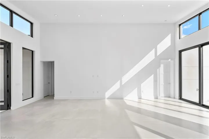 Foyer entrance featuring a towering ceiling and concrete flooring