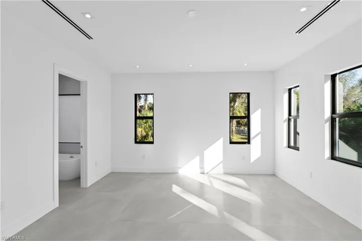 Unfurnished bedroom featuring recessed lighting and connected bathroom