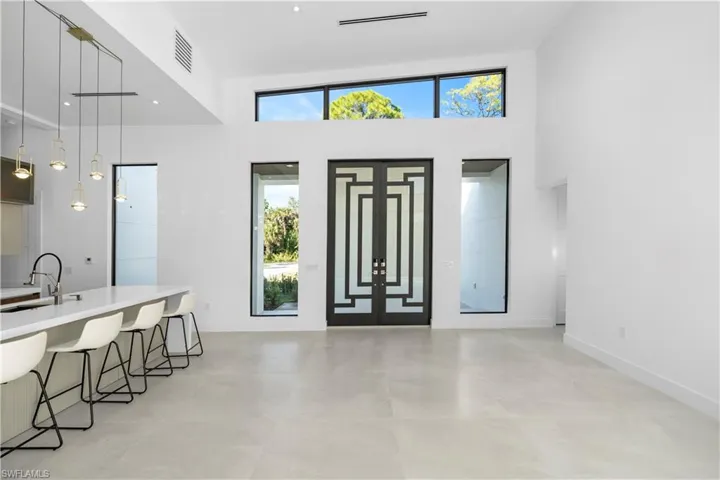 Entrance foyer featuring a towering ceiling and french doors