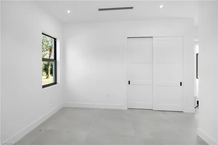 Unfurnished bedroom featuring a closet, recessed lighting, and light tile patterned floors