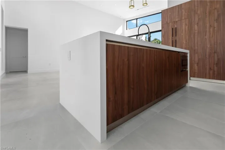 Hallway featuring a high ceiling, wood walls, and light tile patterned flooring