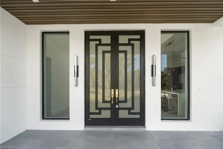 Doorway to property with french doors, stucco siding, and a patio